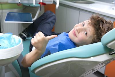 Young boy sitting on dental chair before dental check up in Edina, MN