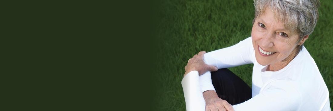 Older woman smiling smiling after getting porcelain veneers from 50th and France Dental Care