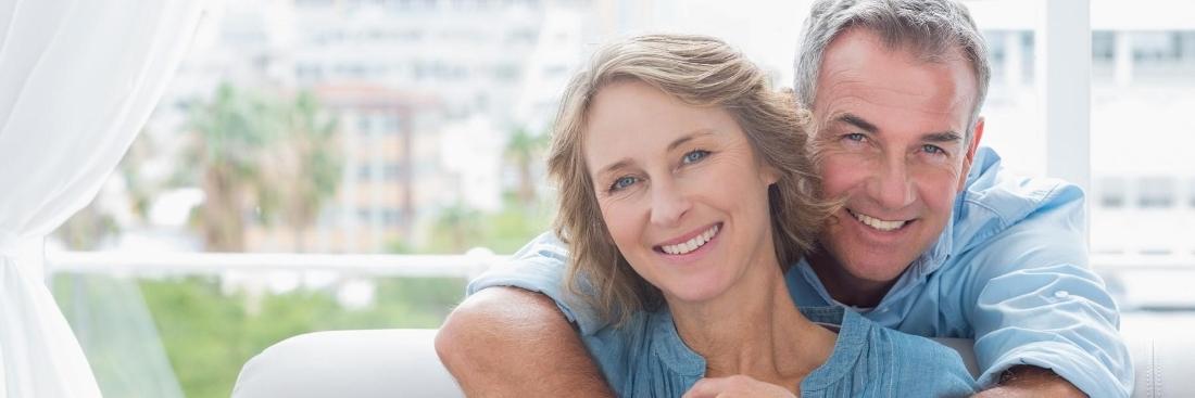 Couple smiling after getting dental implants in Edina, MN